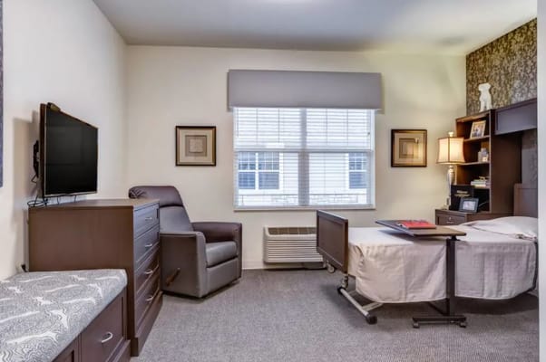 Private resident room with a hospital bed and chair