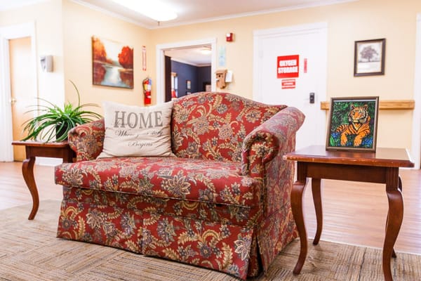 Living room with a floral couch and a side table featuring a tiger painting