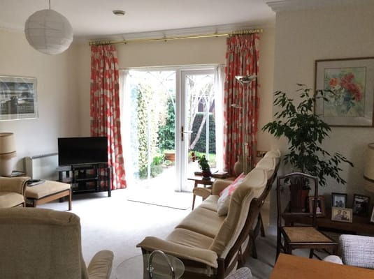 Bright common area with seating and access to garden