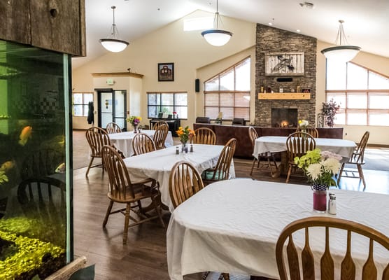 Bright dining area with tables set for meals and an aquarium.