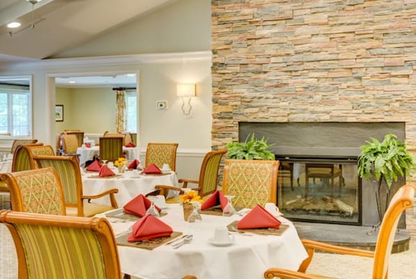 Dining area with beautifully set tables and a stone fireplace