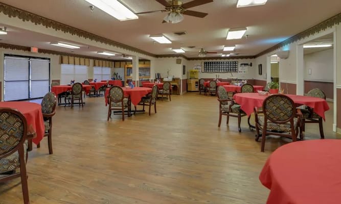 Spacious dining room with red tablecloths and chairs