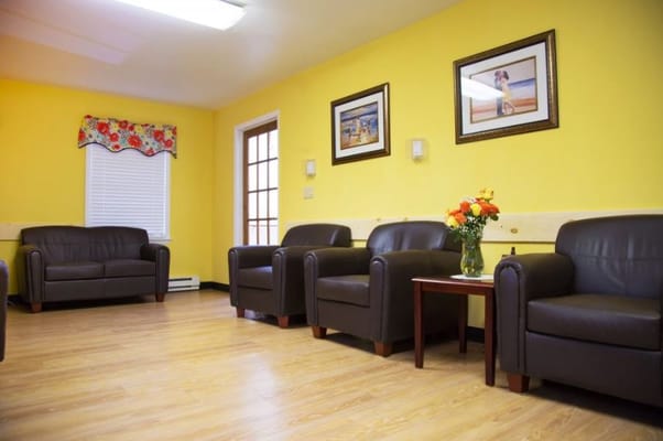 Cozy lounge area with brown chairs and yellow walls
