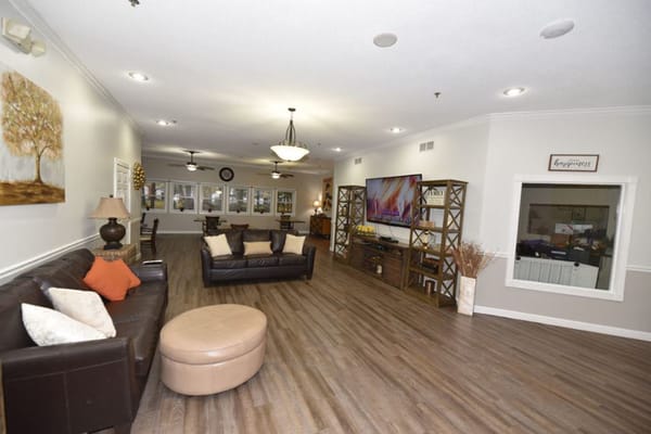 Cozy living room with leather couches and a large TV.