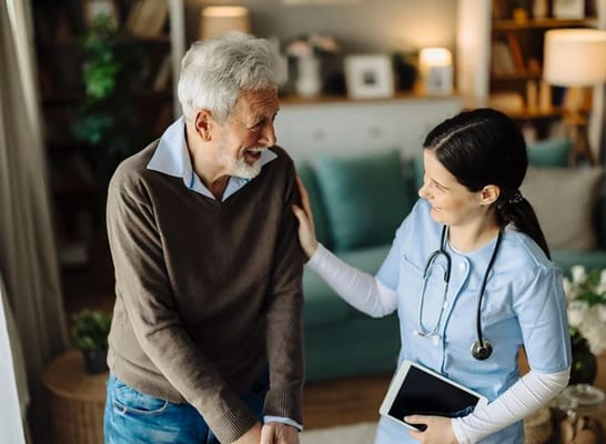 Healthcare worker assisting a senior resident indoors
