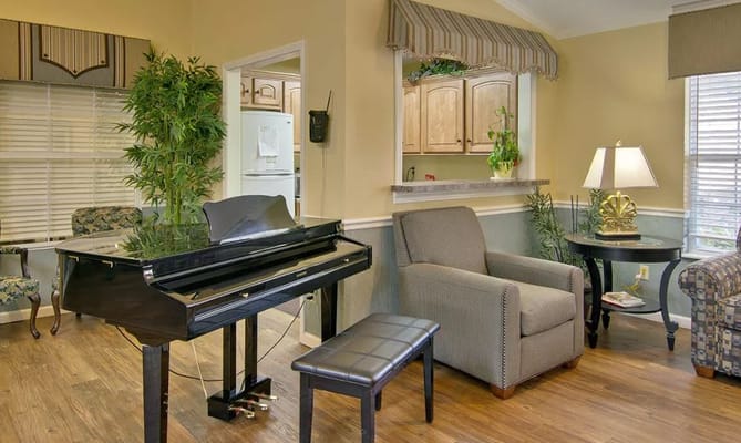 Living room area featuring a black piano and comfortable seating