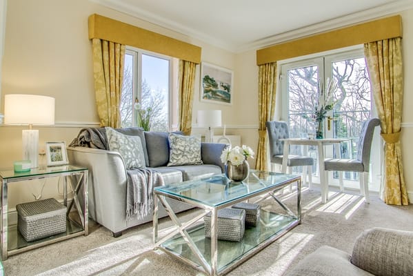 Bright and inviting living room with comfortable seating and a glass coffee table