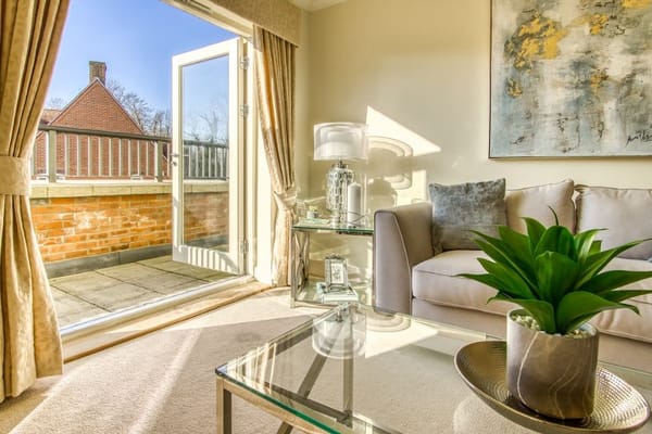 Bright living room featuring a sofa, coffee table, and access to a balcony.