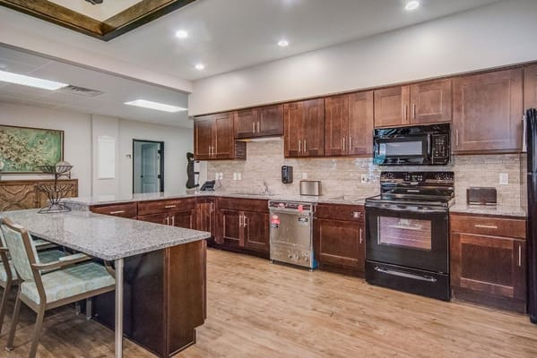 Spacious kitchen with dark wood cabinets and appliances
