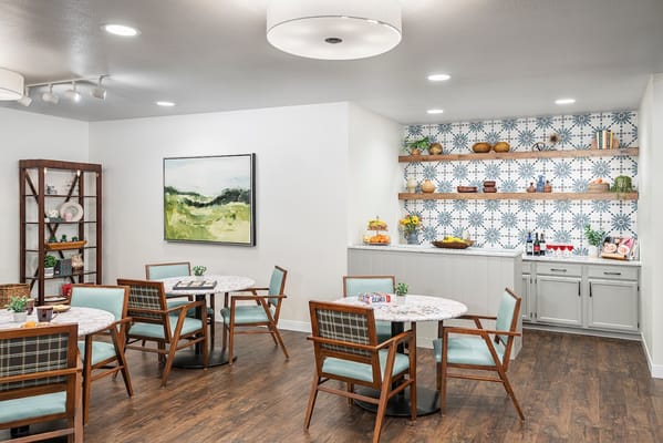 Bright dining area with tables and a decorated shelf
