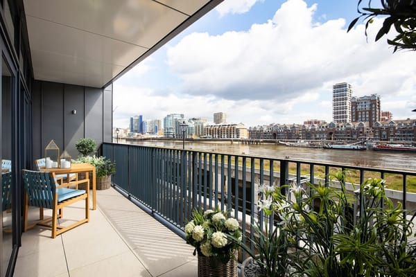 Balcony with a dining table and chairs overlooking the river
