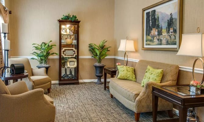 Comfortable living room with two sofas, decorative plants, and artwork.