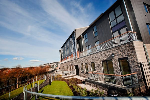 A modern senior living facility with landscaped gardens and walkways