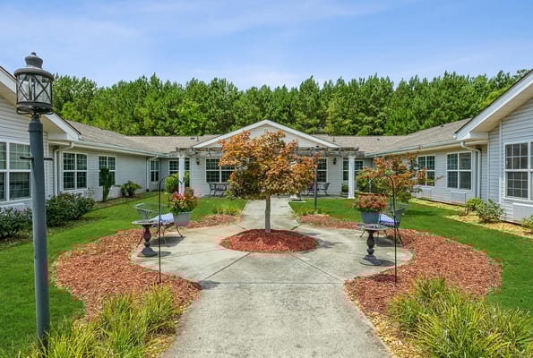 Lush courtyard with benches and flower planters at Seven Hills Square.