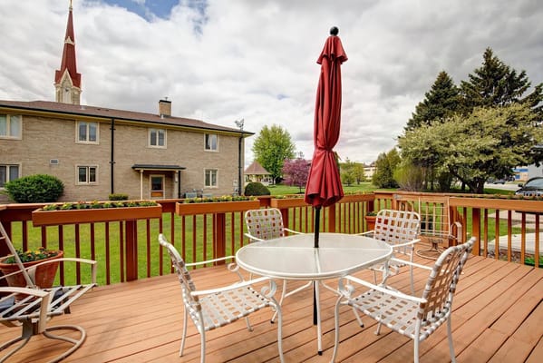 Outdoor seating area with a red umbrella on a deck