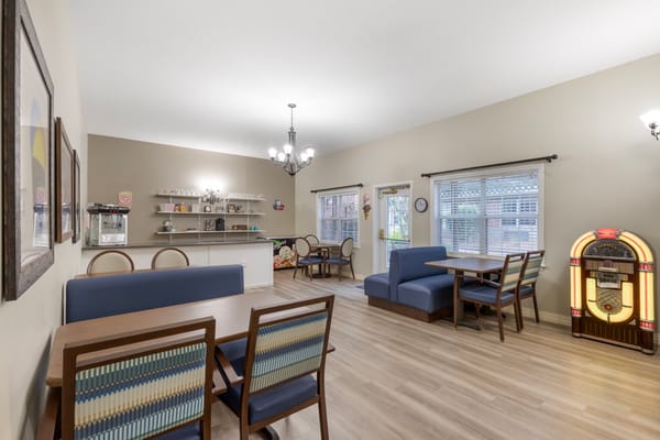Bright common area featuring seating and a jukebox.