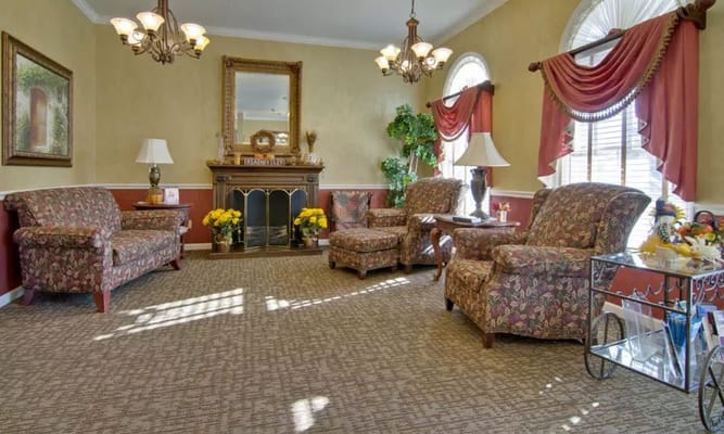 Lounge area with floral-patterned sofas and a fireplace.
