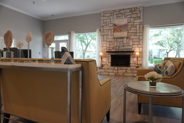 Living room with stone fireplace and yellow armchairs