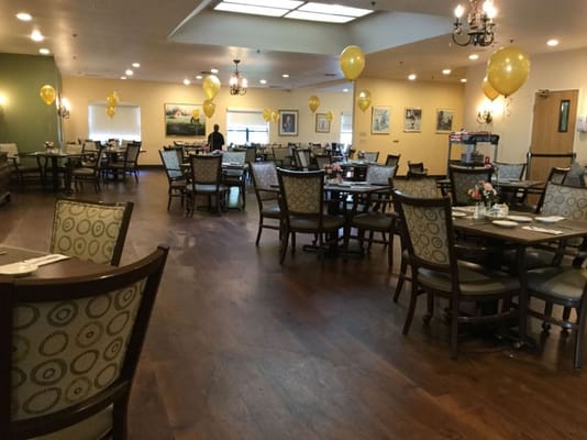 Bright dining room with tables, chairs, and yellow balloons
