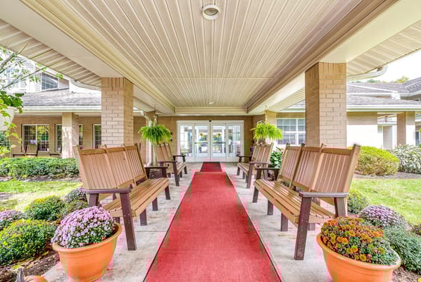 Entrance path with benches and flower pots at Solstice Senior Living