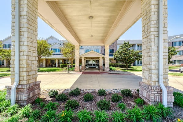 View of the entrance to Solstice Senior Living at Grapevine with landscaped garden.