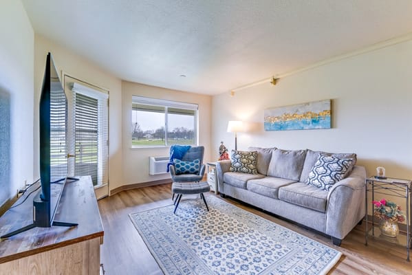 Bright and inviting common area with a cozy couch and large window