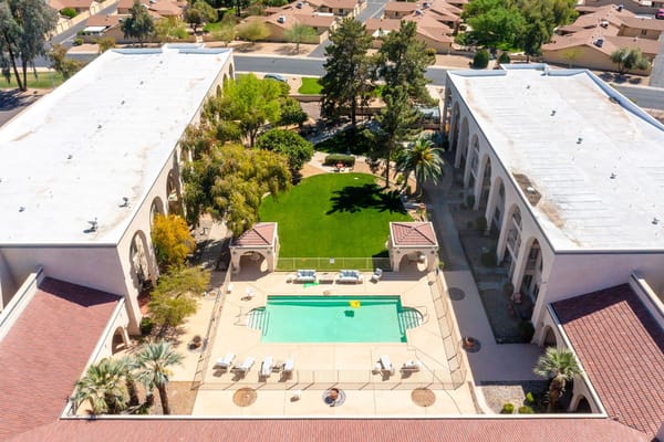 Aerial view of the pool area surrounded by landscaped gardens.