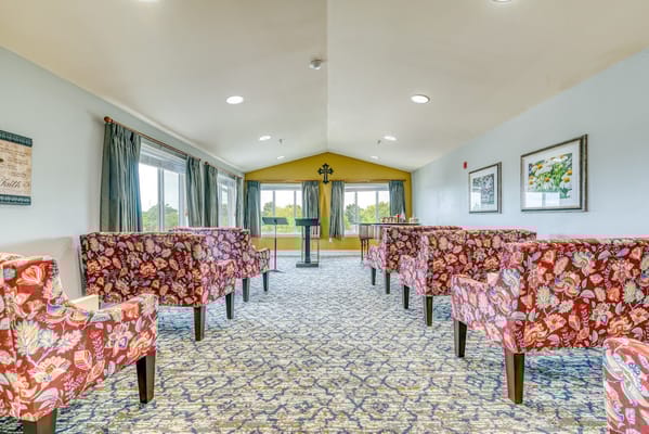 Cozy lounge area with floral chairs and large windows