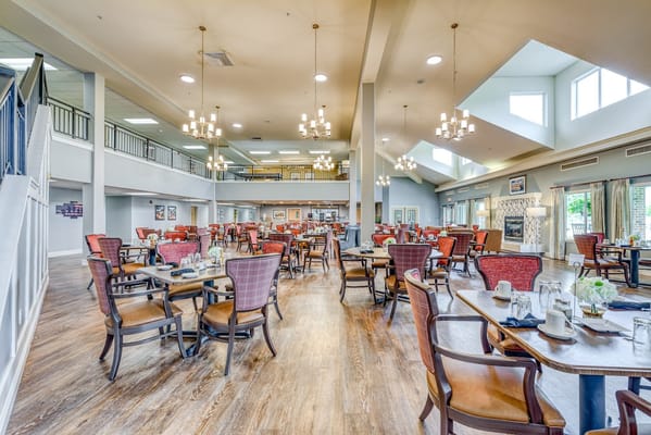 Bright dining area with wooden floors and red upholstered chairs