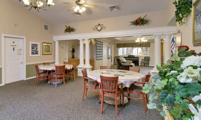A spacious dining area with tables and chairs in South Pointe Senior Living