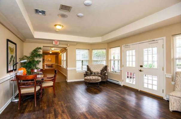 Cozy living room area with seating, windows, and a dining table