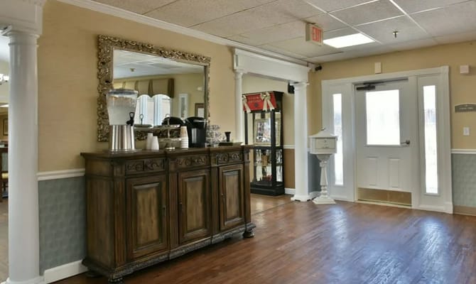 Lobby area with a sideboard, mirror, and entrance door.