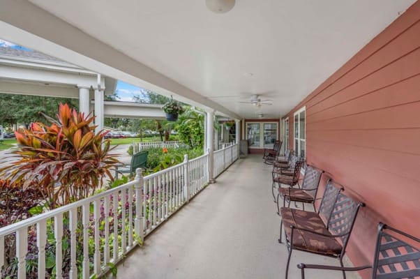 Covered porch with seating and greenery at Spring Hills Hunters Creek.