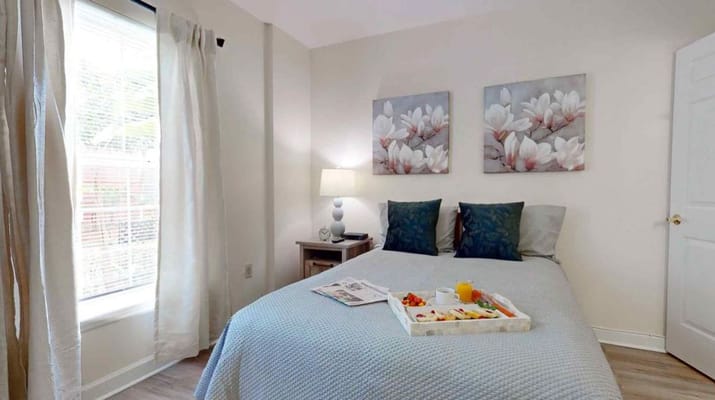 A well-decorated bedroom with a breakfast tray on the bed.
