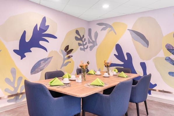 Brightly decorated dining room with a wooden table and blue chairs