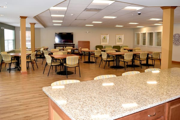 Brightly lit dining area with tables and chairs.
