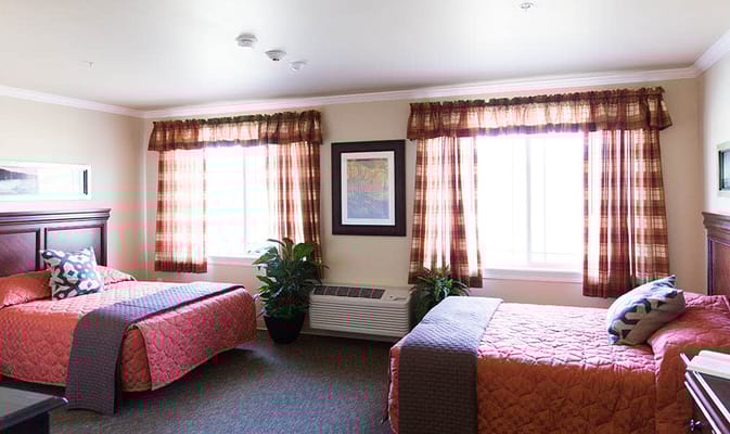 Spacious bedroom with two twin beds and large windows