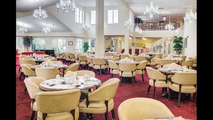 Spacious dining room with round tables and elegant chandeliers