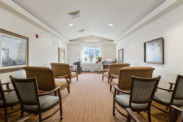 Seating area in community room with artworks and window.