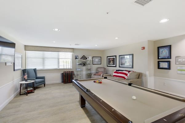 A billiards table set up in a cozy lounge area with seating