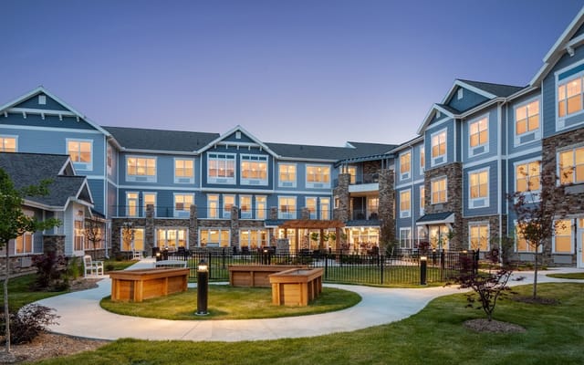 Evening view of the courtyard with seating and landscaping at StoryPoint Northville.
