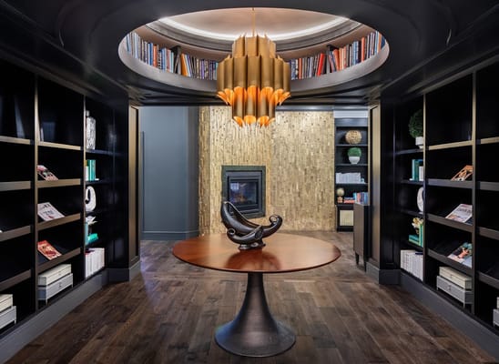 Elegant library lounge with modern decor and a fireplace.