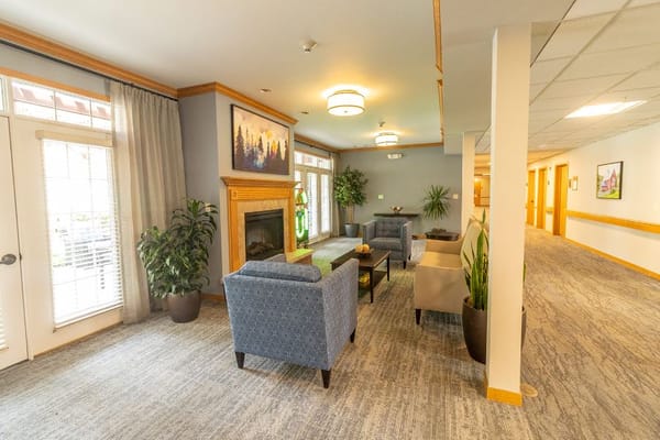 Comfortable lounge with seating, plants, and a fireplace