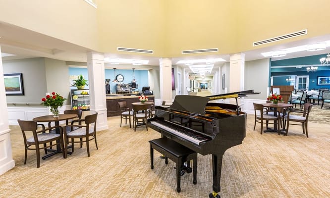Lounge area featuring a grand piano and seating at StoryPoint Waterville.