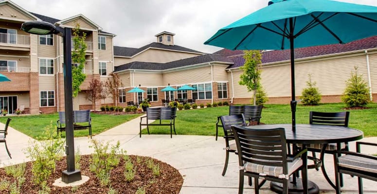 Outdoor seating with turquoise umbrellas at StoryPoint Waterville