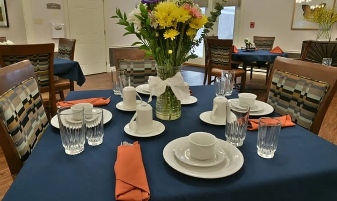 Table set for dining with flowers and utensils at Sugar Creek Senior Living.