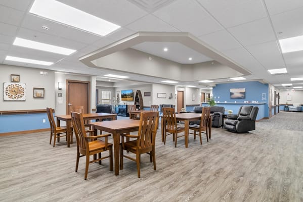 Spacious common area with wooden tables and chairs