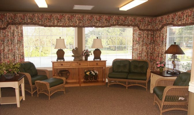 Comfortable seating area in a well-lit room with floral curtains and side tables