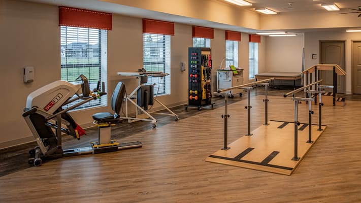Physical therapy equipment in a bright room with windows.
