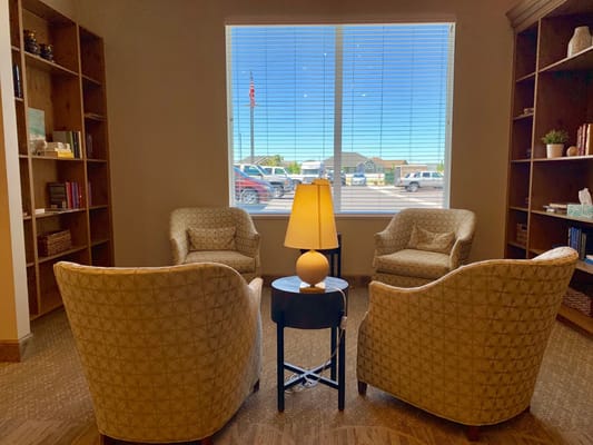Cozy seating area with two patterned chairs and a lamp near a window